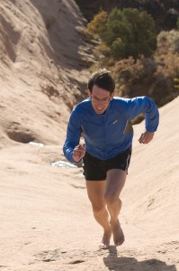 Michael Sanders barefoot running on sandstone slickrock, Moab, Utah.